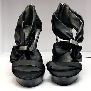 BCBGeneration black heels with logo accent and heel zippers, size 7